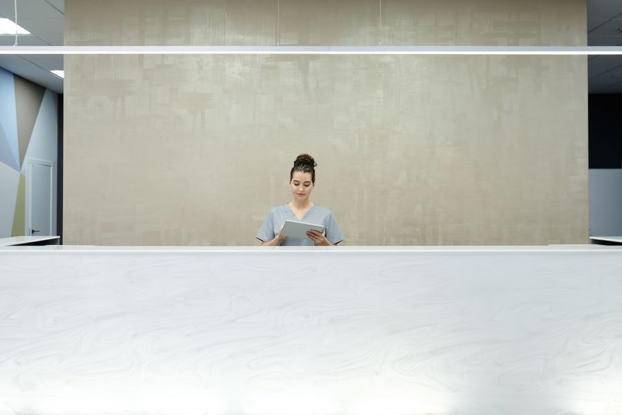 A receptionist using a tablet at a front desk