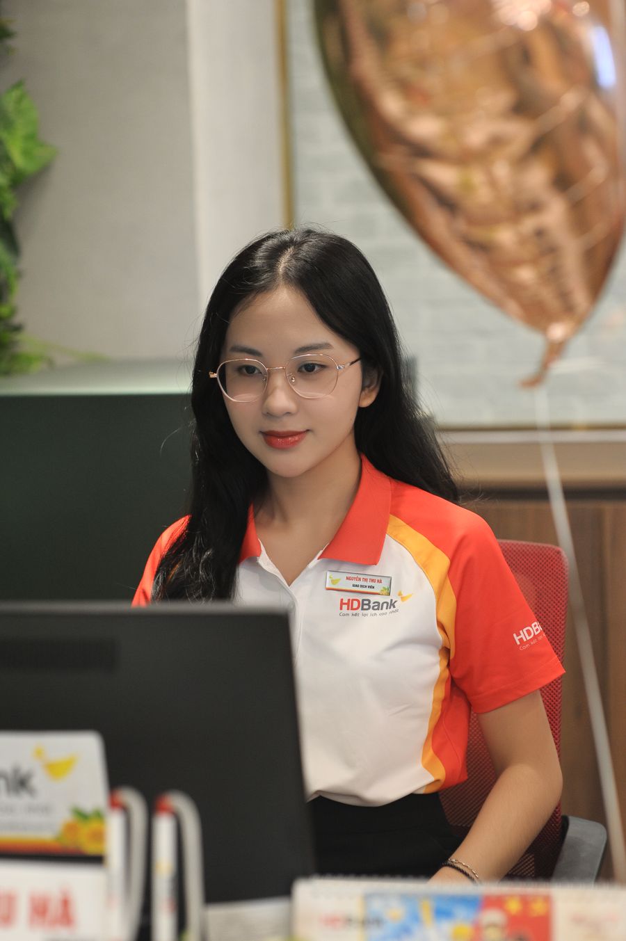 A bank teller helping customers